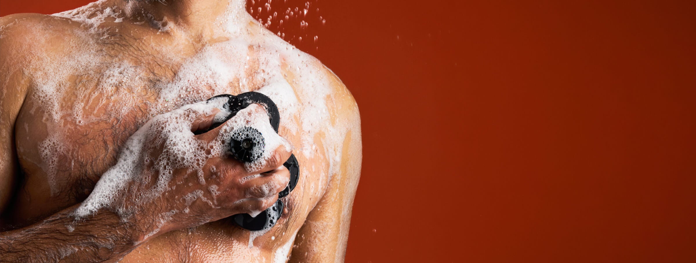 Man washing with a black smoosh, skin full of lather